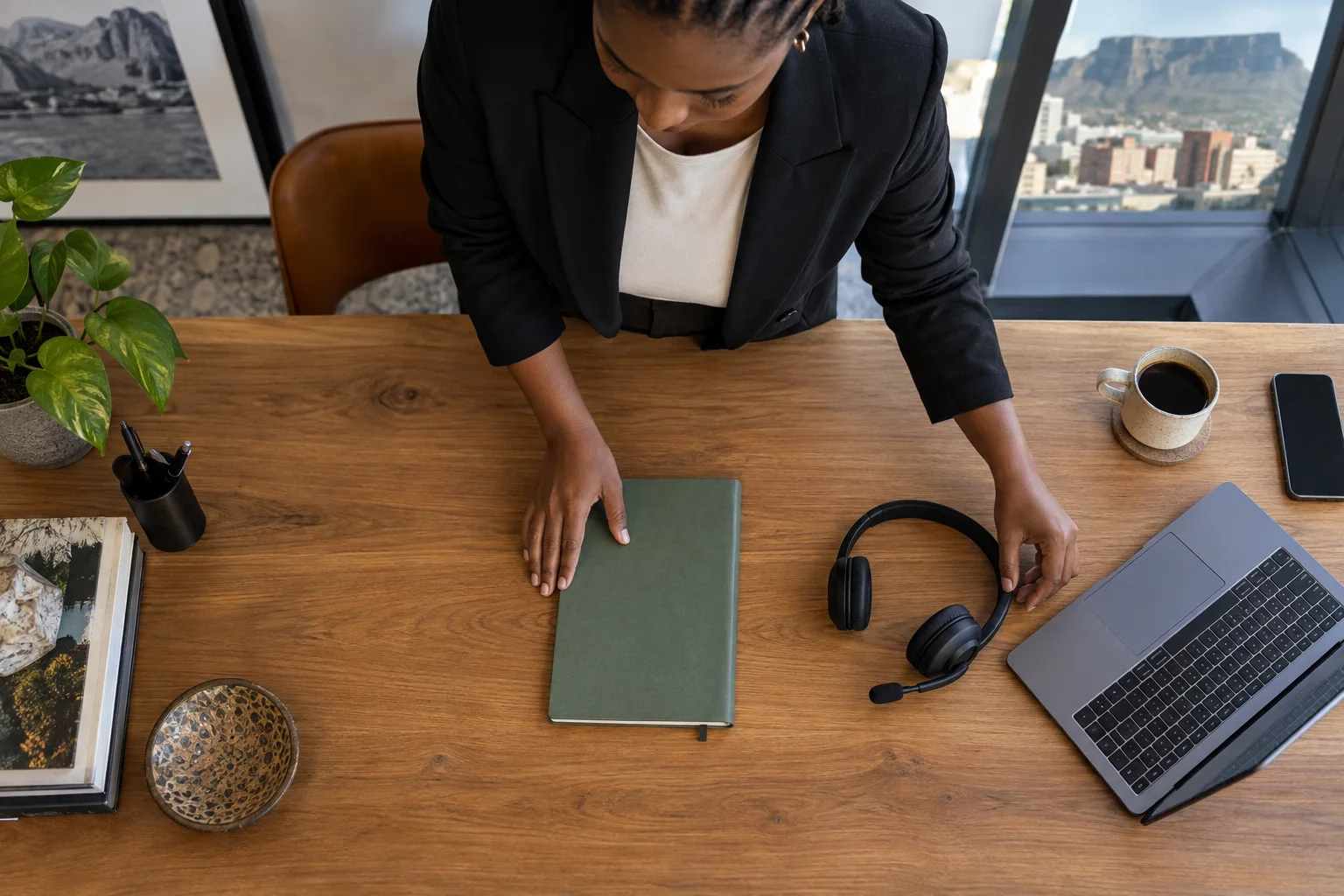 A sales coordinator arranging a clean desk before a team review, overhead view of notebook headset and laptop